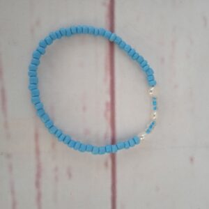 Armbånd med lyseblå og ferskvands perler Omkreds på ca. 18 cm. Det er lavet på elastiksnor, så kan passe de fleste.