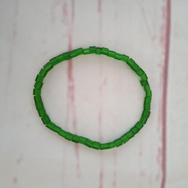 Armbånd med mat grønne perler Omkreds på ca. 18 cm. Det er lavet på elastiksnor, så kan passe de fleste.
