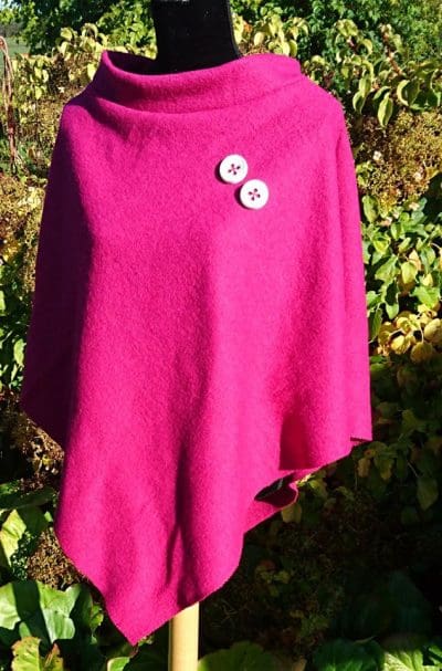 Poncho i ren uld. Cerise med hvide knapper.